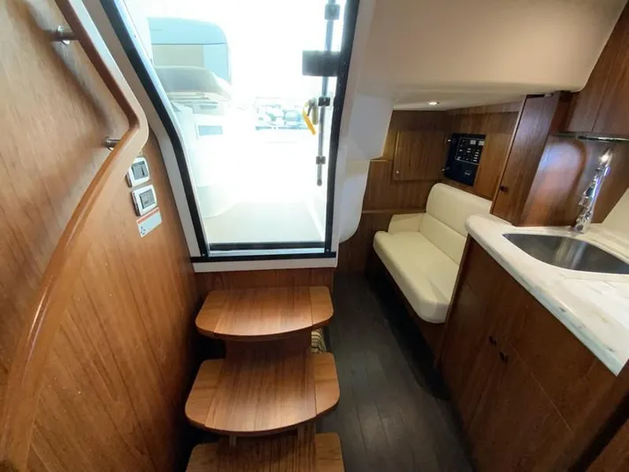 Intuition Yacht Photos Pics Interior of 2013 Tiara Yachts 36, featuring wooden steps, seating, and kitchenette.