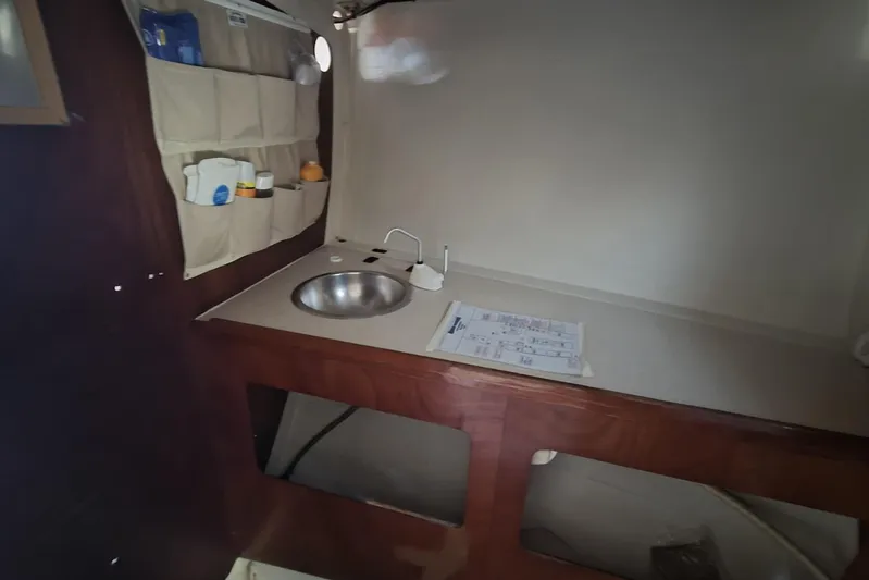 Grand Illusion Yacht Photos Pics Interior of 1986 Santa Cruz 70 yacht with sink, storage pockets, and countertop.