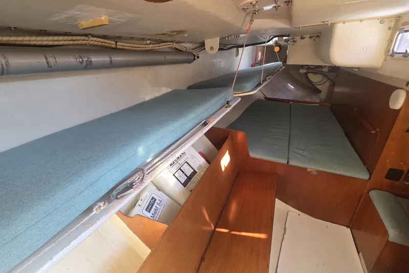 Grand Illusion Yacht Photos Pics Interior of 1986 Santa Cruz 70 sailboat with blue cushions and wooden accents.