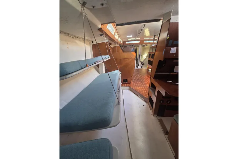 Grand Illusion Yacht Photos Pics Interior of 1986 Santa Cruz 70 sailboat with blue cushions and wooden accents.