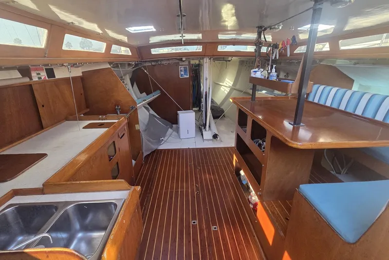 Grand Illusion Yacht Photos Pics Interior of 1986 Santa Cruz 70 sailboat with wooden finishes and striped seating.