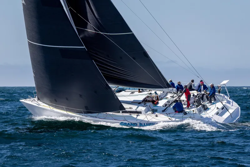 Grand Illusion Yacht Photos Pics Sailing yacht Santa Cruz 70, 1986 model, navigating ocean waters with crew onboard.