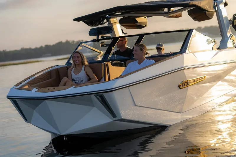  Yacht Photos Pics 2026 Nautique Super Air Nautique G25 Coastal Edition cruising with passengers at sunset.