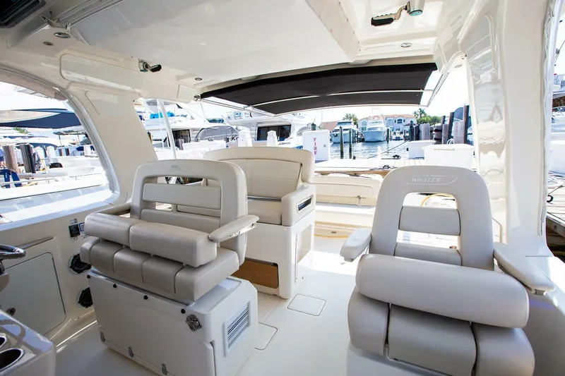  Yacht Photos Pics 2019 Boston Whaler 380 Realm interior with luxurious seating and marina view.