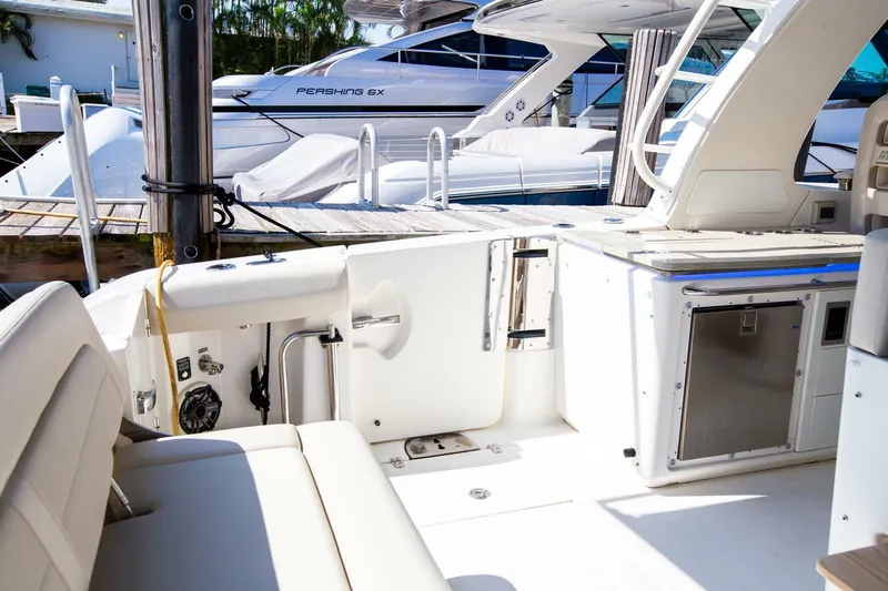  Yacht Photos Pics 2019 Boston Whaler 380 Realm interior with white seating and docked boats in background.
