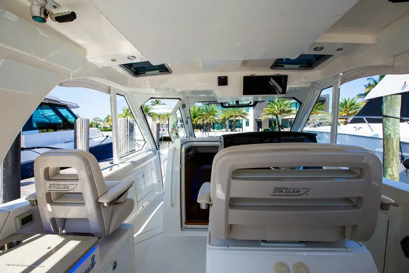  Yacht Photos Pics Interior view of 2019 Boston Whaler 380 Realm boat, featuring modern seating and controls.