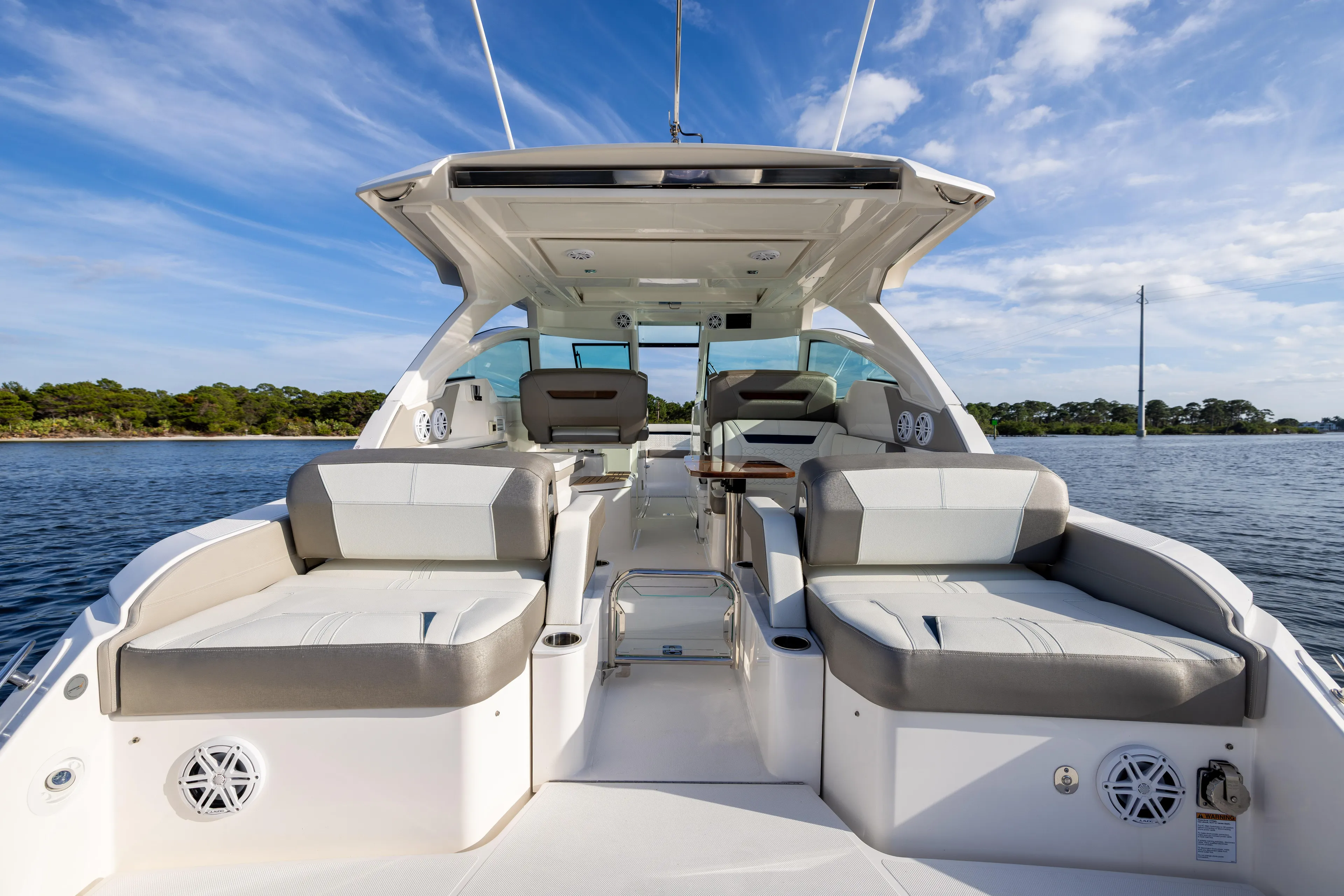 34 Tiara 2022 Yacht Photos Pics 2022 Tiara 34 LX luxury boat interior with seating, on a serene water backdrop.