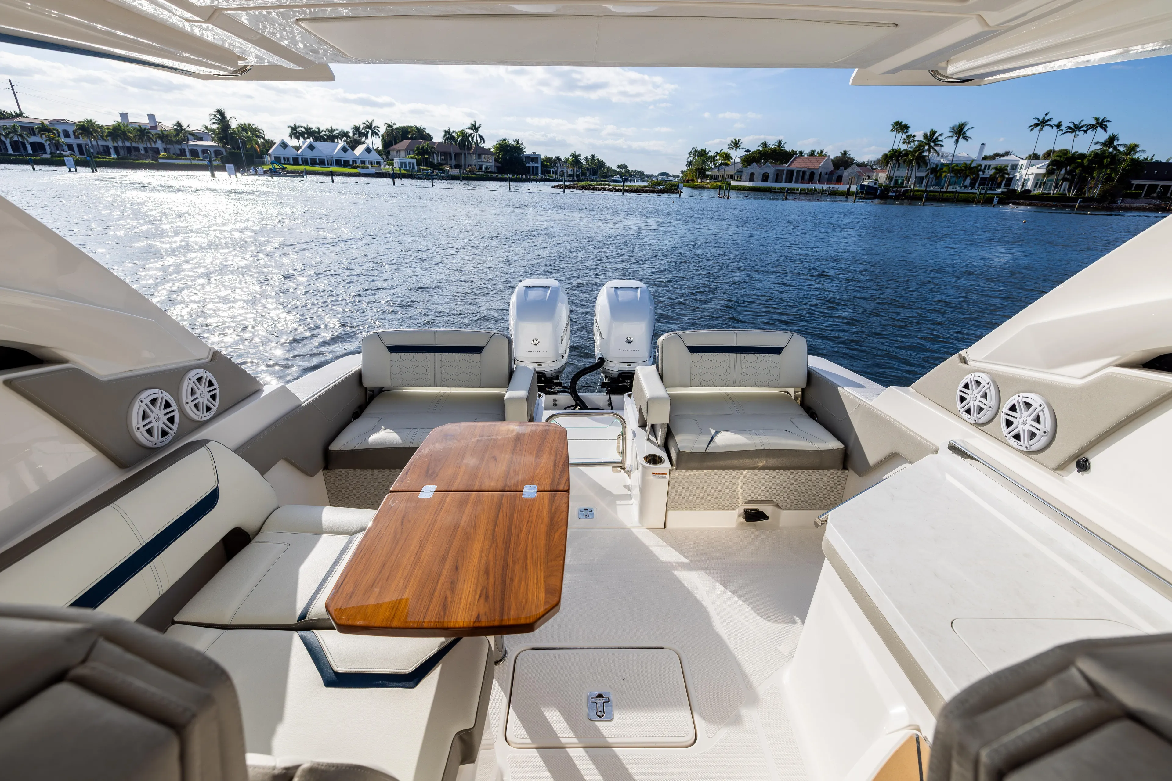 34 Tiara 2022 Yacht Photos Pics Luxurious 2022 Tiara 34 LX yacht interior with seating and table, overlooking serene waterfront.