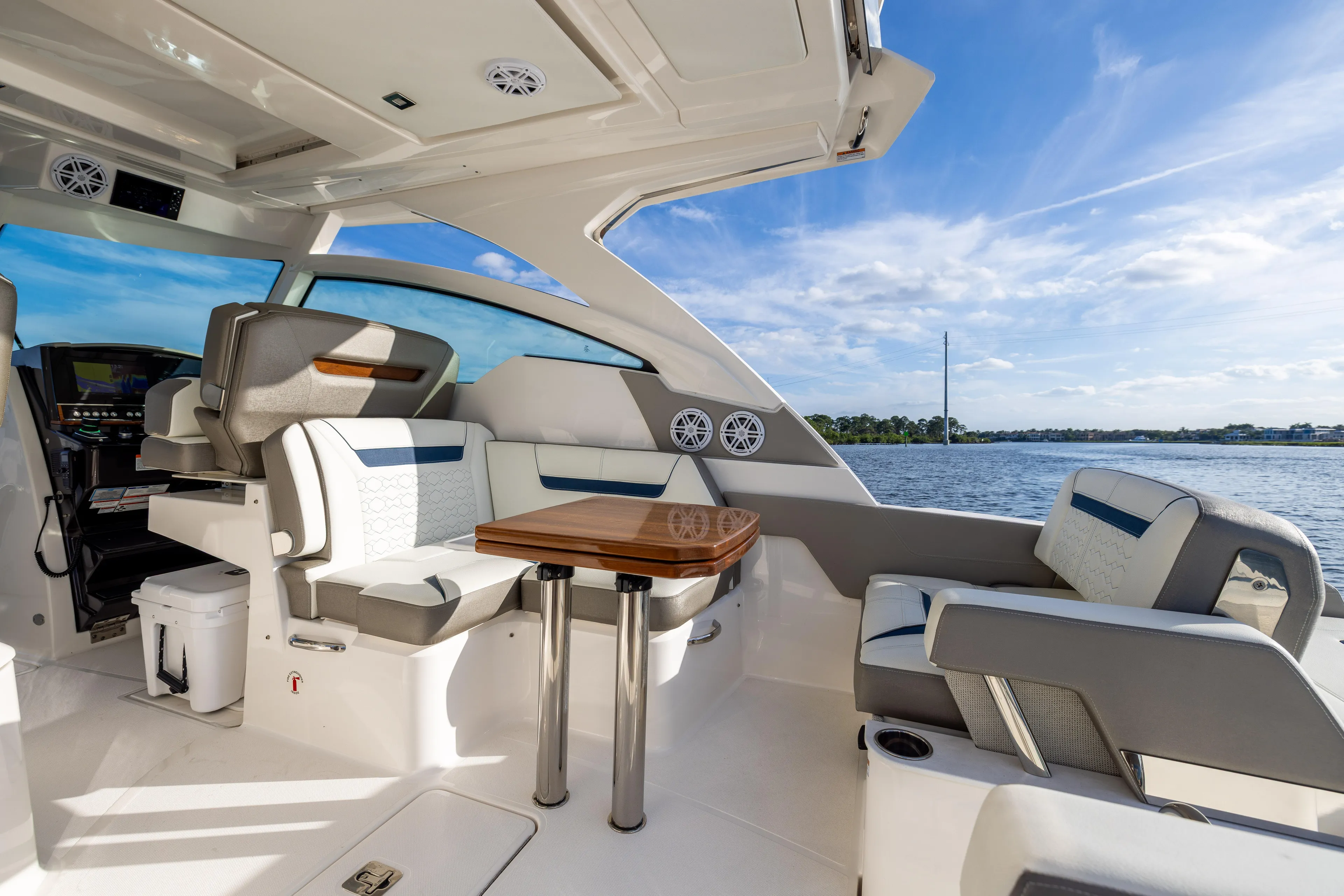 34 Tiara 2022 Yacht Photos Pics Luxurious interior of 2022 Tiara 34 LX yacht with seating and table, overlooking water.