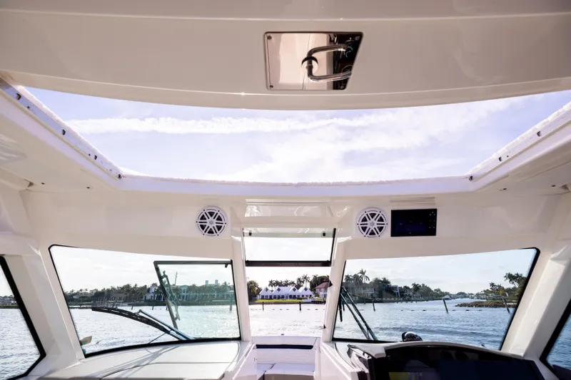 34 Tiara 2022 Yacht Photos Pics Interior view of 2022 Tiara 34 LX boat with open sunroof and waterfront scenery.