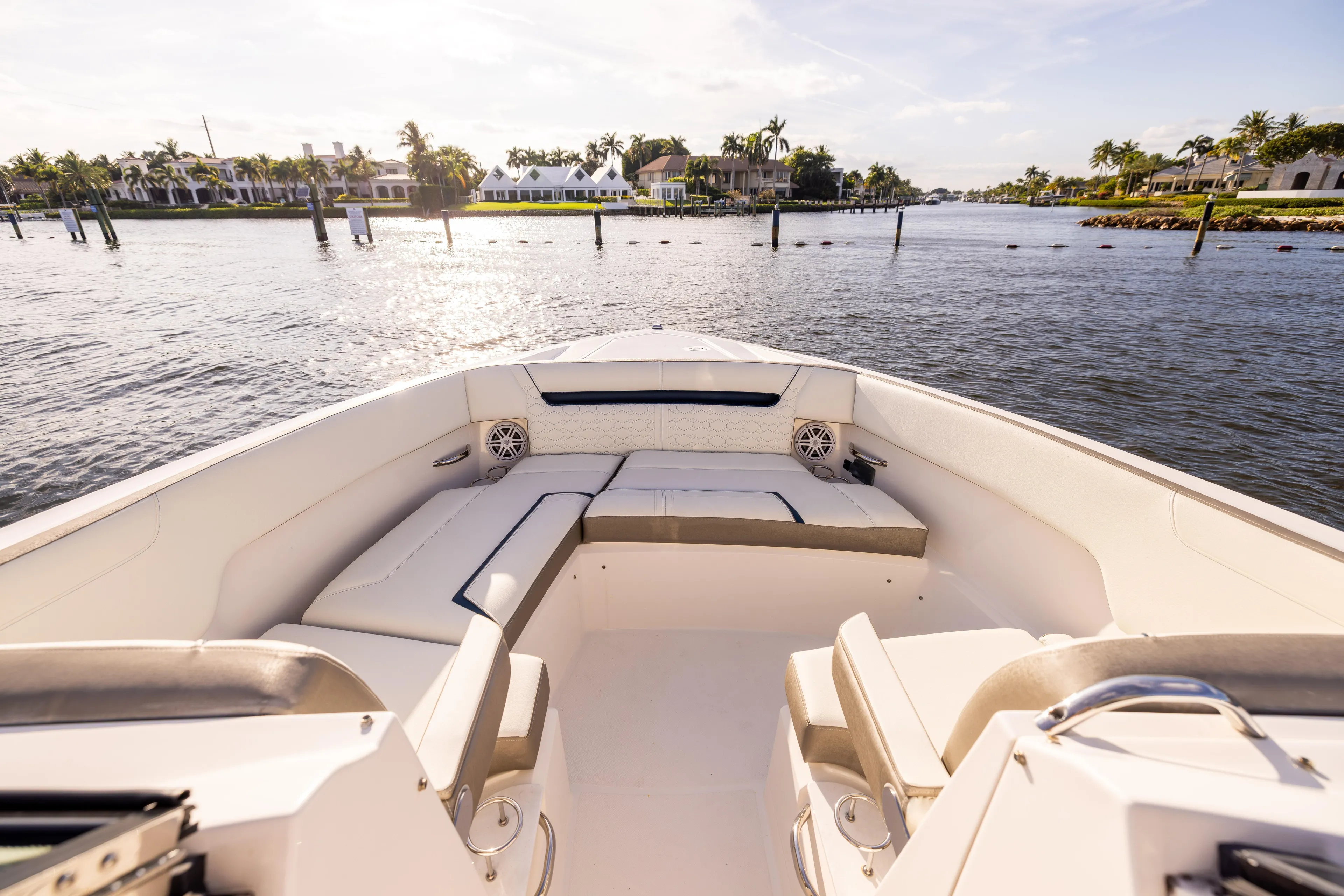 34 Tiara 2022 Yacht Photos Pics 2022 Tiara 34 LX boat interior with luxurious seating, cruising on a sunny waterfront.