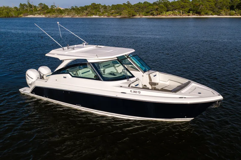 34 Tiara 2022 Yacht Photos Pics 2022 Tiara 34 LX boat on calm water, featuring sleek design and dual outboard engines.