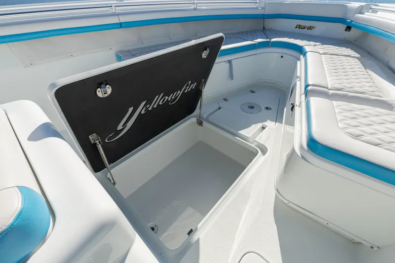 Fins Up Yacht Photos Pics 2017 Yellowfin 42 Offshore boat interior with open storage compartment and cushioned seating.