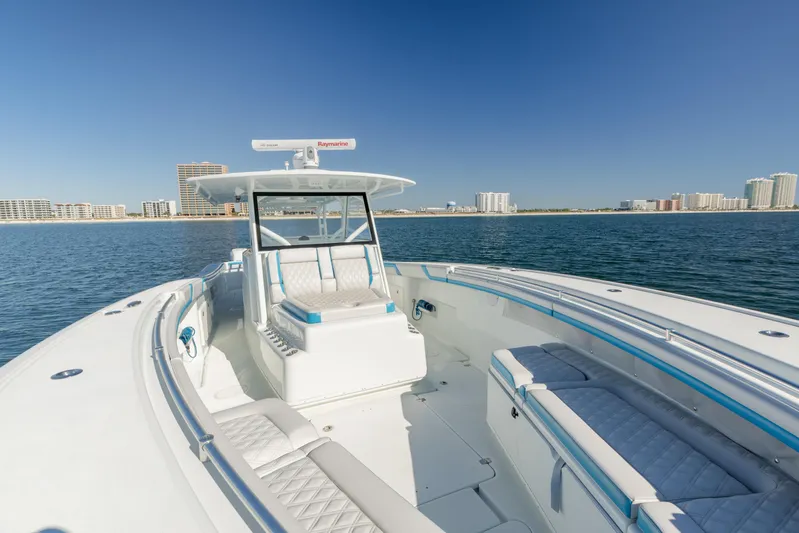 Fins Up Yacht Photos Pics 2017 Yellowfin 42 Offshore boat on calm waters with city skyline in background.