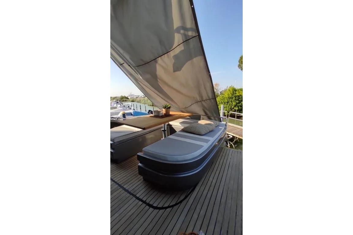 Luxurious deck of 2004 AB Yachts 68 with sunbed and canopy.