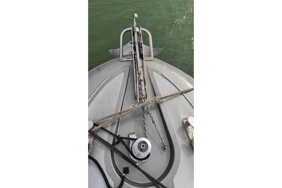 Bow of 2004 AB Yachts 68 with anchor and ropes on calm water.