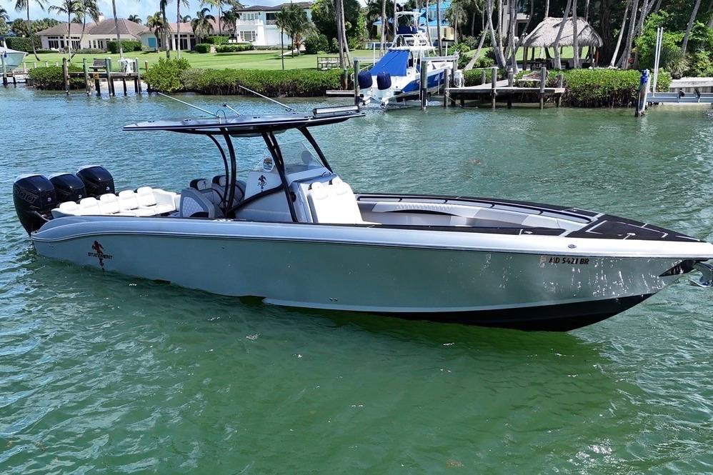 2016 Statement 380 Open boat on calm water, featuring sleek design and triple engines.