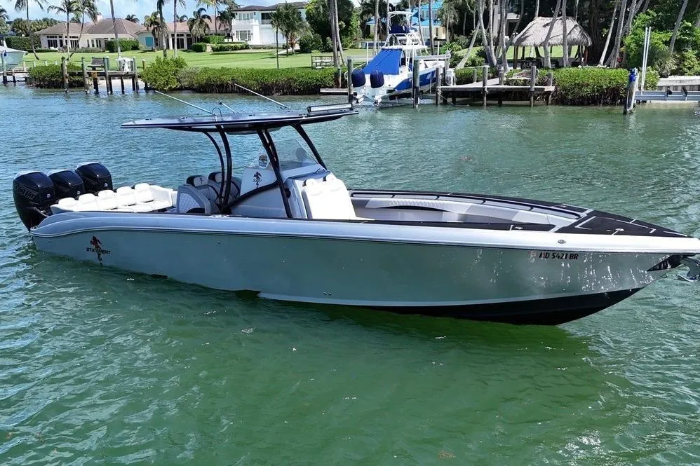 2016 Statement 380 Open boat on calm water, featuring sleek design and triple engines.
