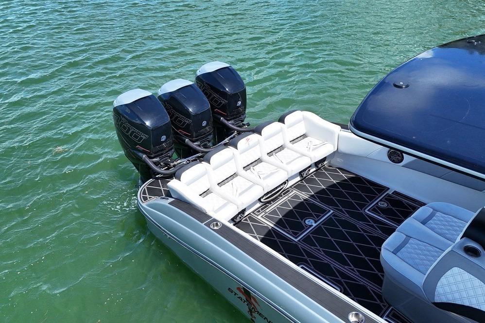 2016 Statement 380 Open boat with triple outboard engines on water.
