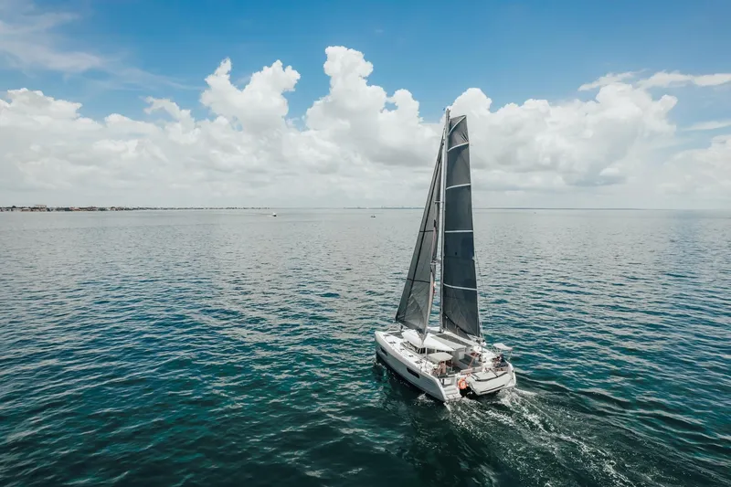 27 Reasons Yacht Photos Pics Sailing catamaran Excess 12, 2020 model, cruising on open sea under blue sky.
