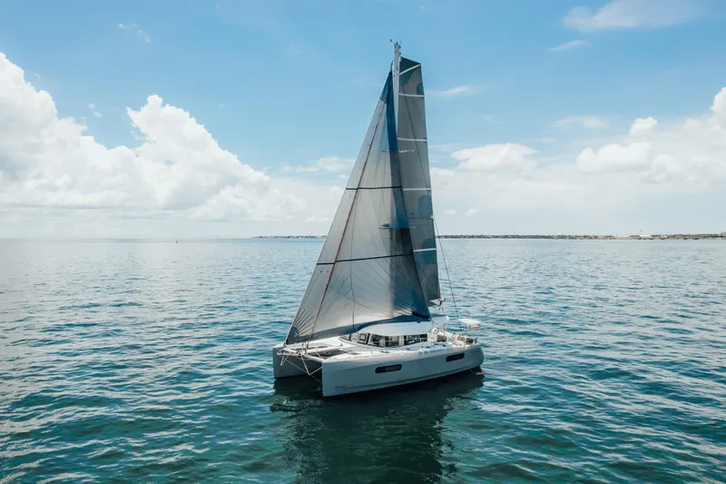 27 Reasons Yacht Photos Pics Sailing catamaran Excess 12, 2020 model, gliding on calm ocean waters under a clear sky.
