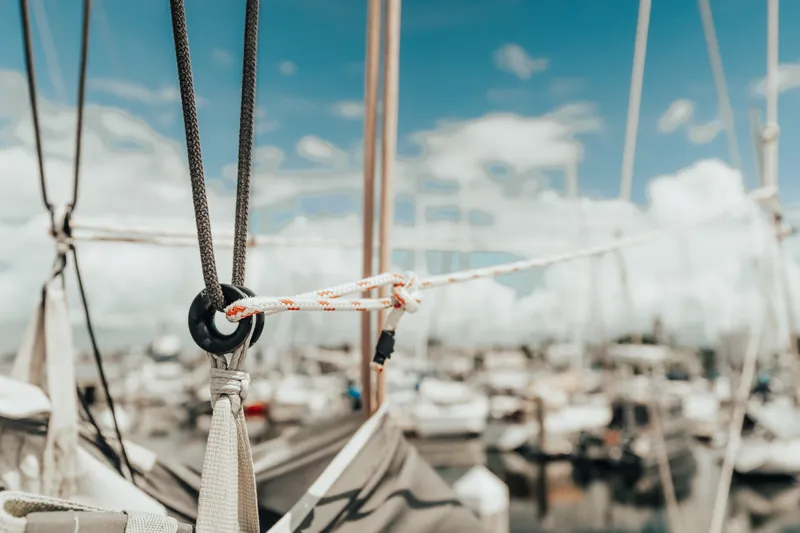 27 Reasons Yacht Photos Pics Close-up of sailing ropes on a 2020 Excess 12 catamaran, marina background.