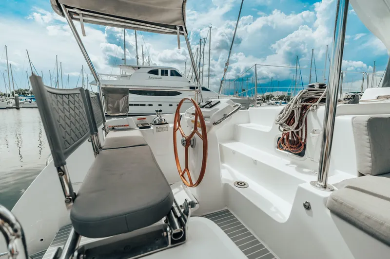 27 Reasons Yacht Photos Pics Cockpit of 2020 Excess 12 catamaran in marina, featuring steering wheel and seating.