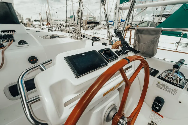27 Reasons Yacht Photos Pics Steering wheel and controls of a 2020 Excess 12 sailboat, docked at a marina.