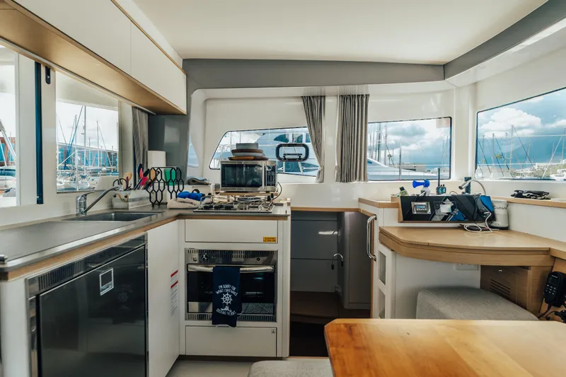 27 Reasons Yacht Photos Pics Modern kitchen interior of 2020 Excess 12 catamaran with appliances and marina view.