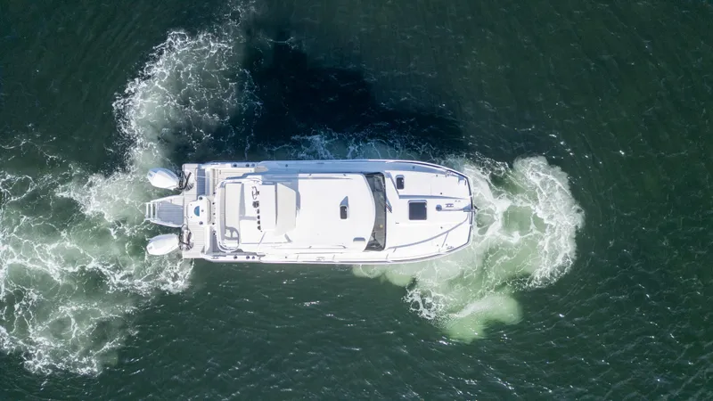 Transcendent Yacht Photos Pics Aerial view of 2023 ArrowCat Flybridge Dual Helm boat navigating water.