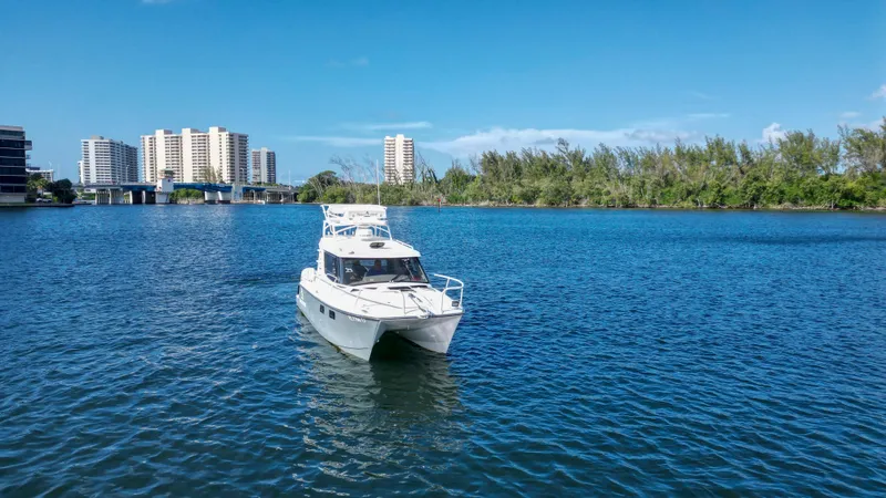 Transcendent Yacht Photos Pics 2023 ArrowCat Flybridge Dual Helm boat on a serene blue waterway.