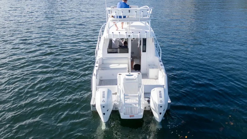 Transcendent Yacht Photos Pics 2023 ArrowCat Flybridge Dual Helm boat on water, rear view, with dual outboard engines.