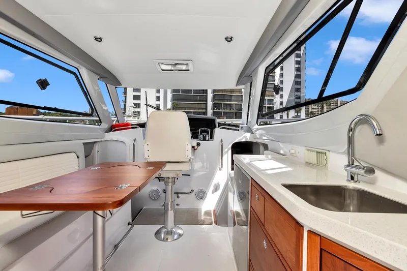 Transcendent Yacht Photos Pics Interior of 2023 ArrowCat Flybridge Dual Helm with table, chair, and kitchenette.