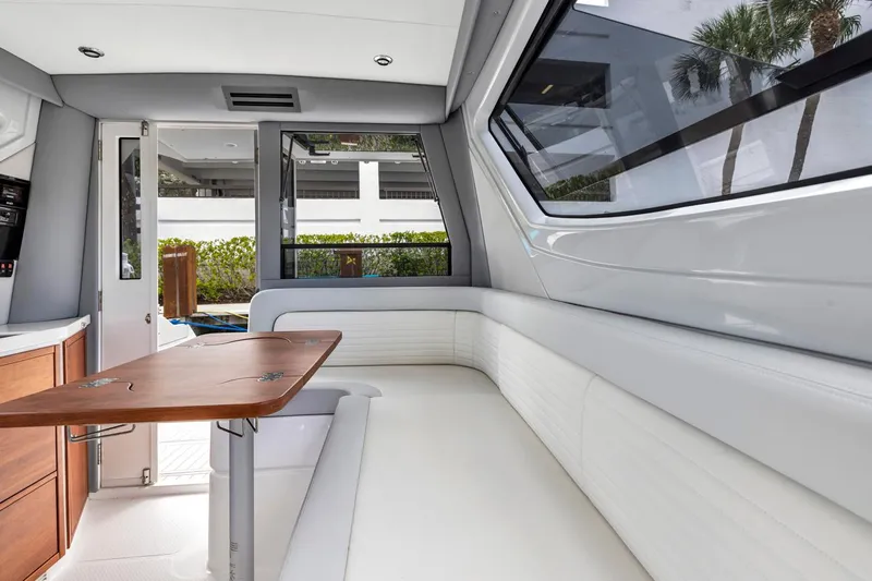 Transcendent Yacht Photos Pics Luxurious interior of 2023 ArrowCat Flybridge Dual Helm with sleek seating and wooden table.