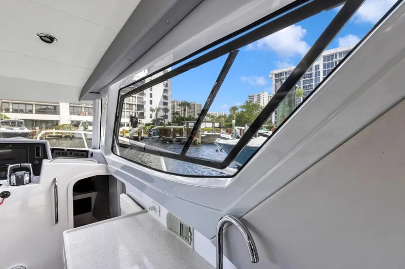 Transcendent Yacht Photos Pics 2023 ArrowCat Flybridge Dual Helm interior with marina view through large windows.