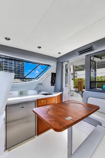 Transcendent Yacht Photos Pics 2023 ArrowCat Flybridge Dual Helm interior with kitchenette and wooden table, featuring modern design.