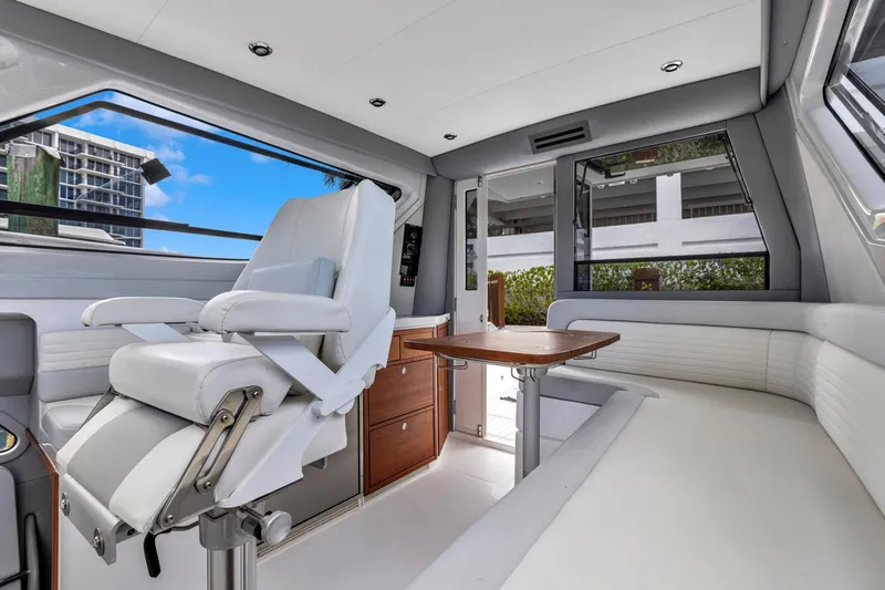 Transcendent Yacht Photos Pics 2023 ArrowCat Flybridge Dual Helm interior with white seating and wooden table.