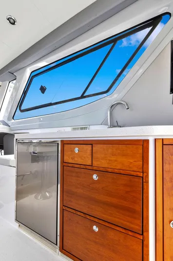 Transcendent Yacht Photos Pics 2023 ArrowCat Flybridge Dual Helm yacht interior with wooden cabinetry and sleek window design.