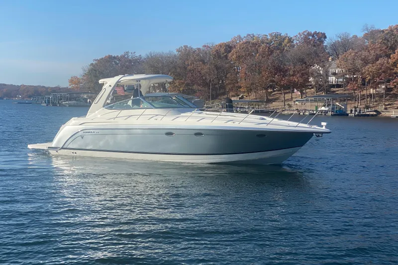  Yacht Photos Pics 2005 Formula 40 Performance Cruiser on a serene lake with autumn trees in the background.