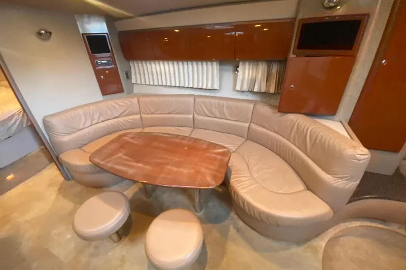  Yacht Photos Pics Luxurious interior of 2005 Formula 40 Performance Cruiser with curved seating and wooden table.