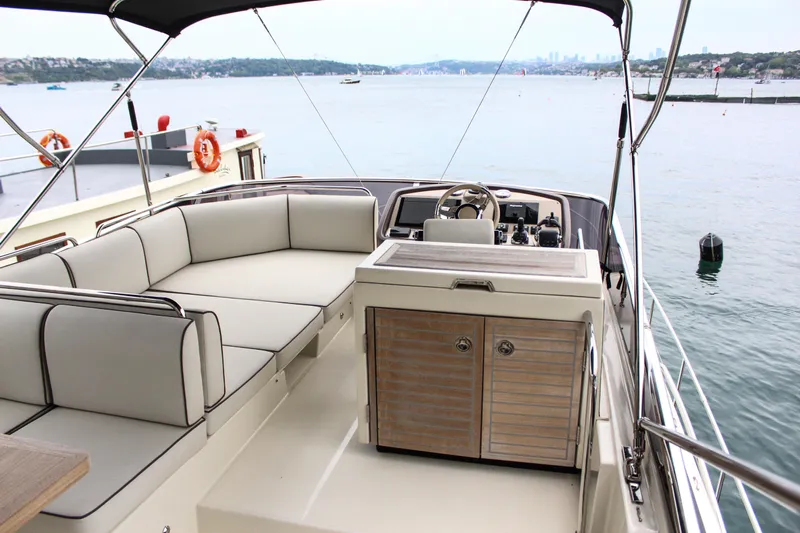 Oxygen Yacht Photos Pics 2016 Beneteau Monte Carlo 5 yacht interior with seating and helm, overlooking serene waters.