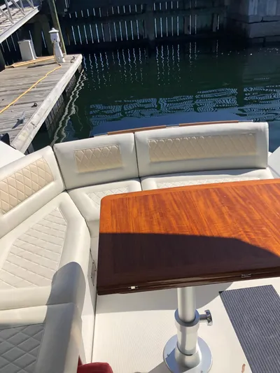  Yacht Photos Pics Beneteau Gran Turismo 41, 2019 model, featuring elegant seating and wooden table by the dock.