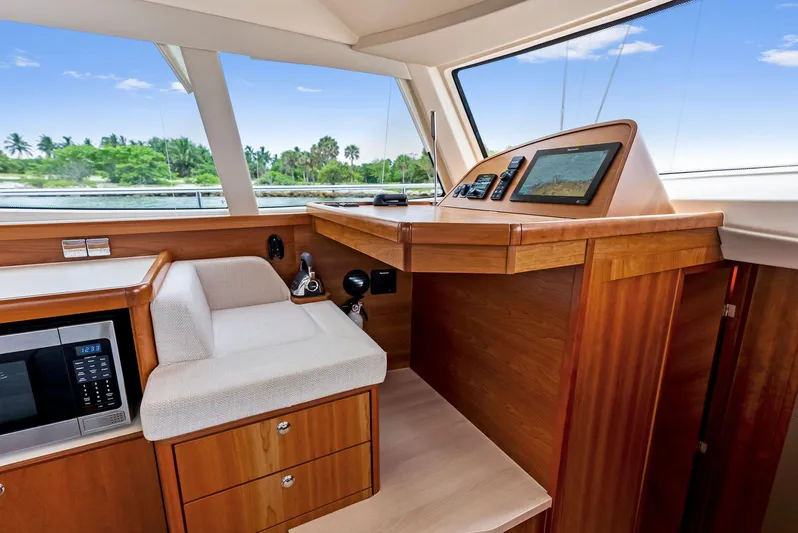 Southwind Yacht Photos Pics Interior helm station of 2021 Moody 45 DS yacht with wooden cabinetry and navigation equipment.