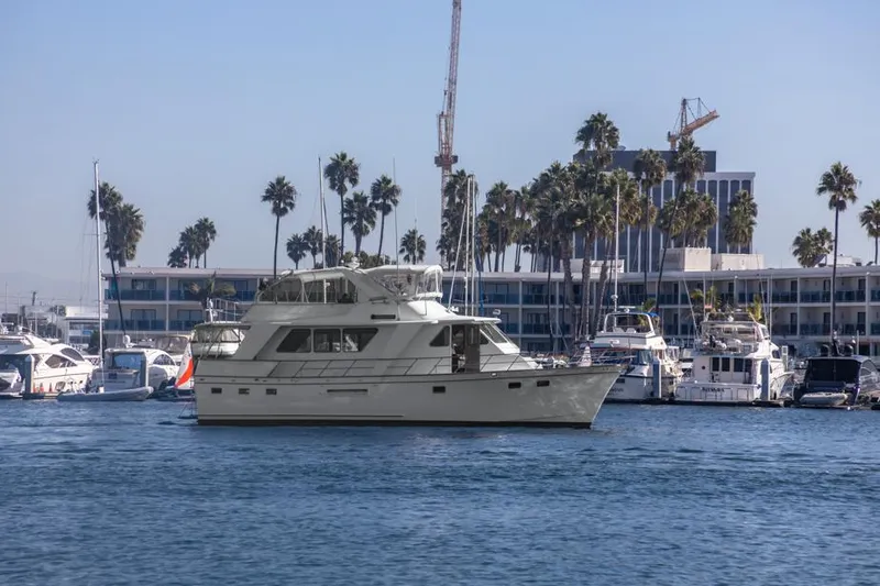 Betelgeuse Yacht Photos Pics 1988 DeFever 53 POC yacht docked in marina with palm trees and buildings in background.