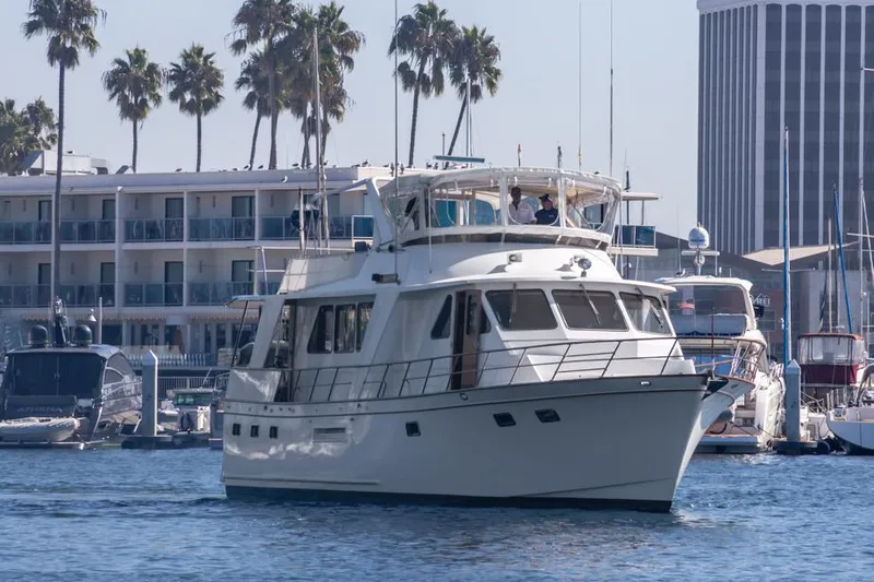 Betelgeuse Yacht Photos Pics 1988 DeFever 53 POC yacht docked in marina with palm trees and buildings.
