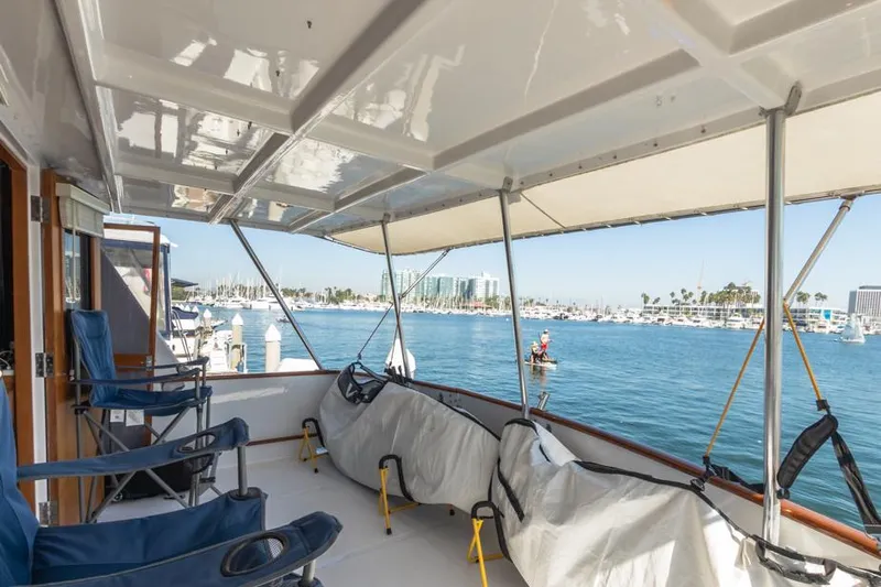 Betelgeuse Yacht Photos Pics 1988 DeFever 53 POC yacht deck with chairs, overlooking marina and waterfront.