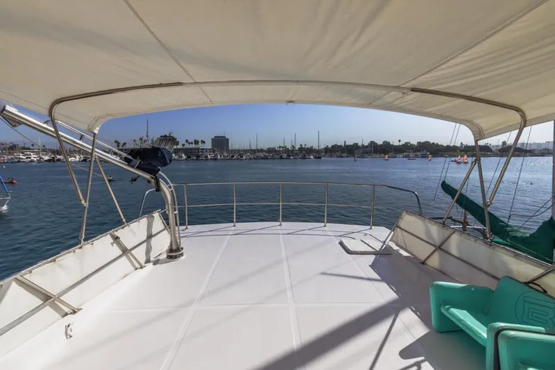 Betelgeuse Yacht Photos Pics DeFever 53 POC 1988 yacht deck with canopy, overlooking marina and calm waters.