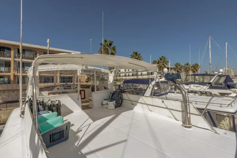 Betelgeuse Yacht Photos Pics 1988 DeFever 53 POC yacht deck with seating, docked at marina under clear sky.