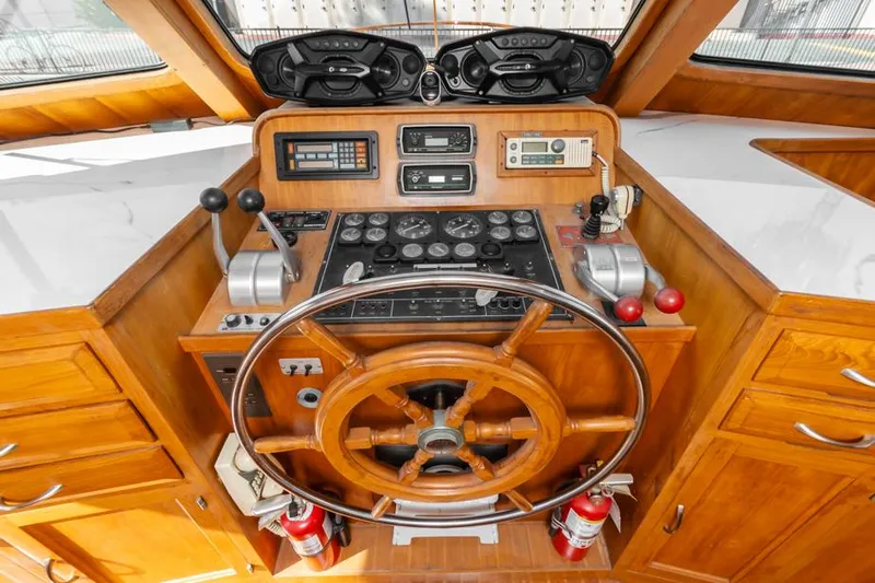 Betelgeuse Yacht Photos Pics 1988 DeFever 53 POC helm with wooden wheel and navigation controls.
