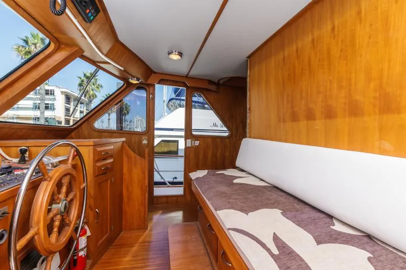 Betelgeuse Yacht Photos Pics 1988 DeFever 53 POC yacht interior with wooden helm and seating area.